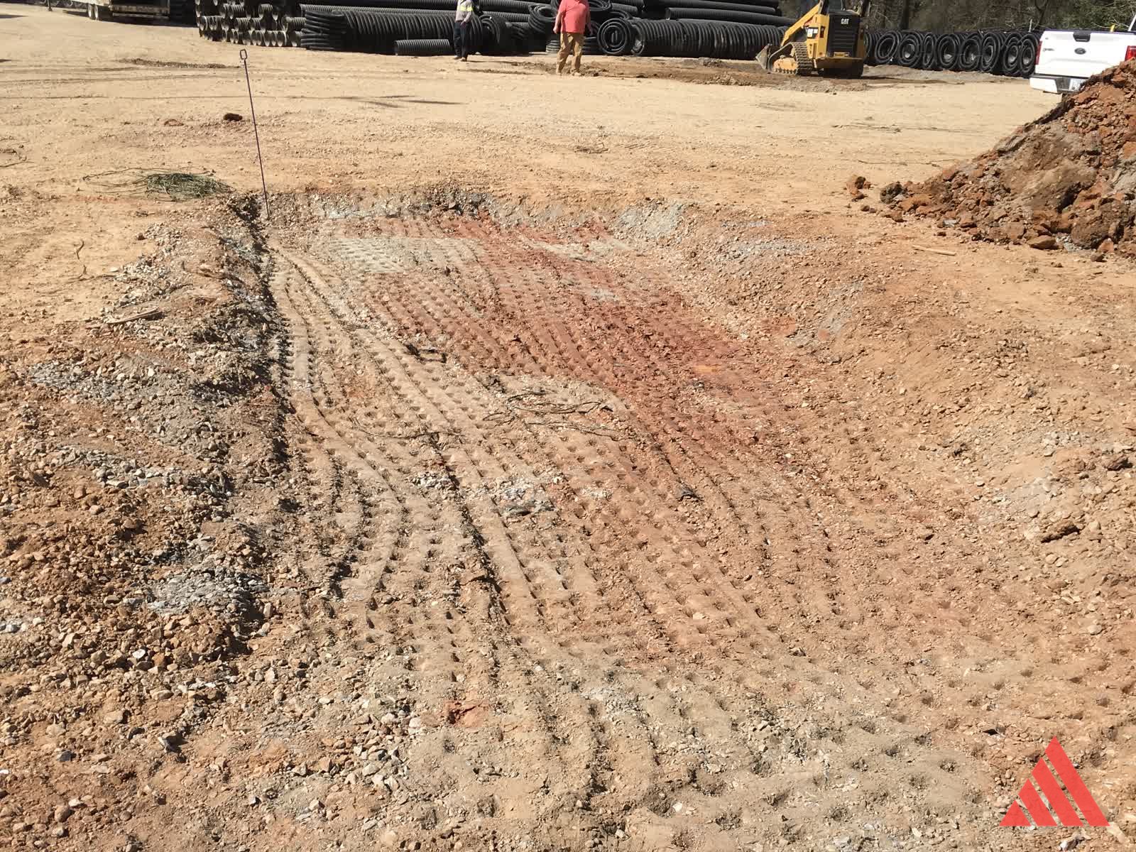Graded yard area with ADS pipe inventory and construction equipment